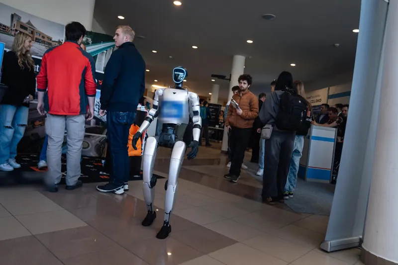 Humanoid prochází mezi návštěvníky odborné konference