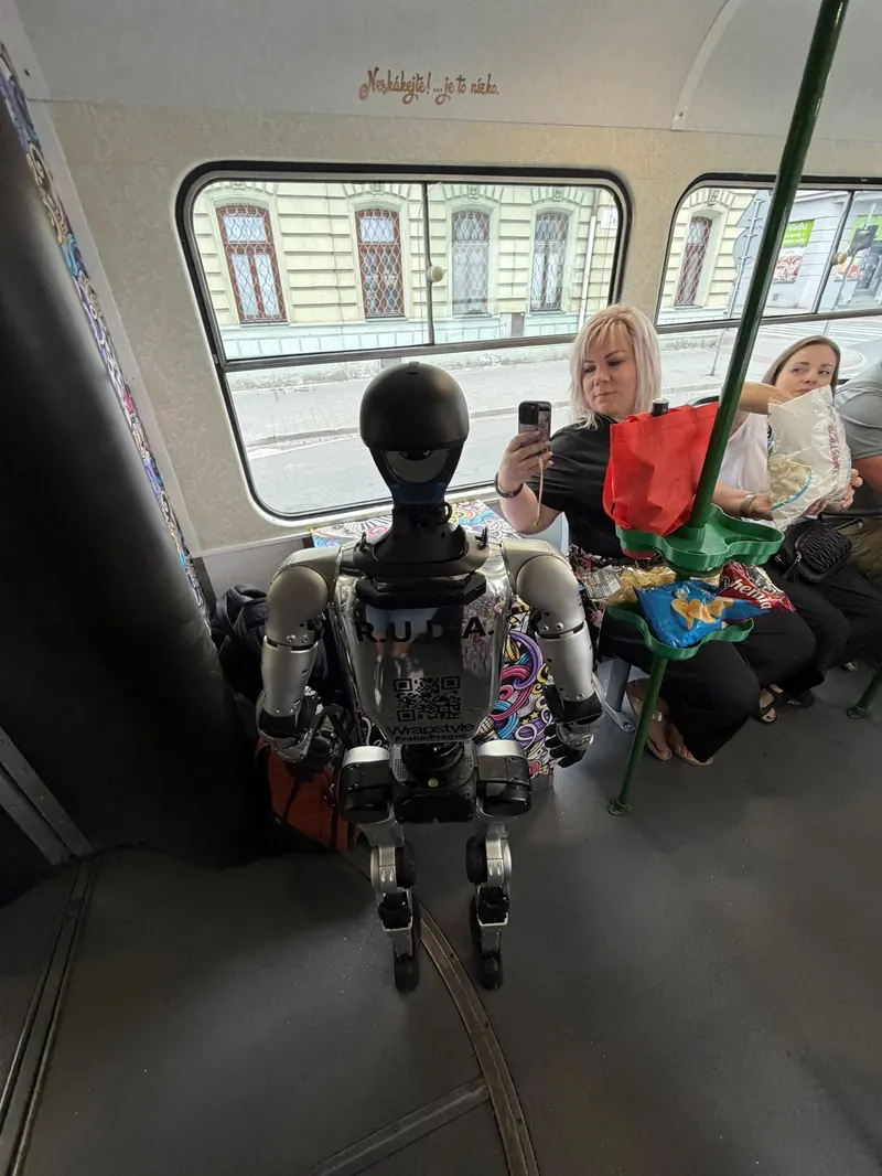 Humanoid ve vyhlídkové tramvaji, hostka si ho fotí