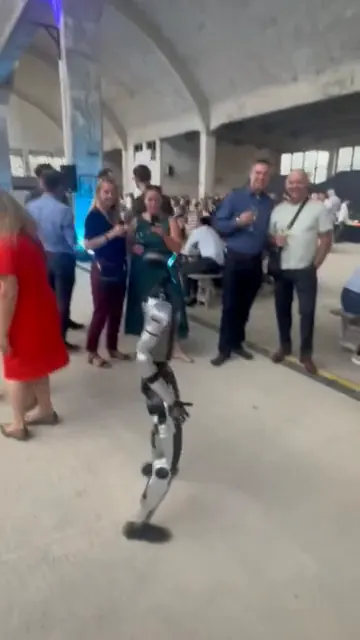 Humanoid tančí v hale před hosty večírku