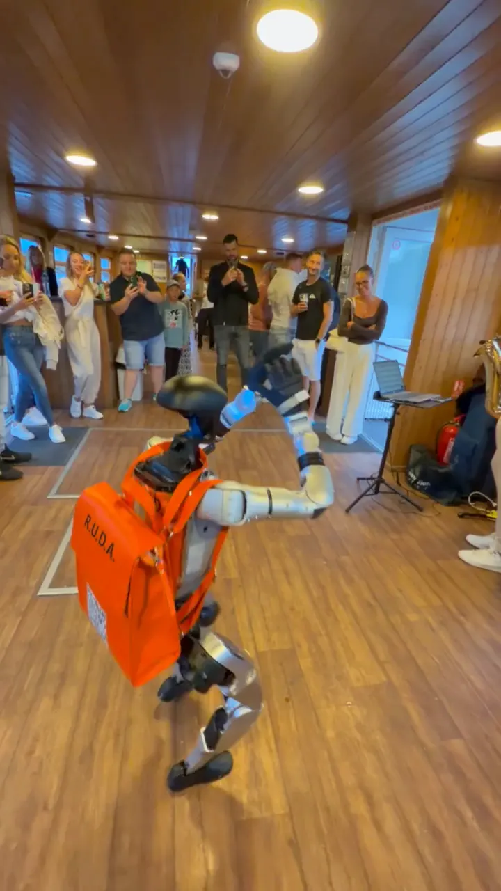 Humanoid tančí v salonu lodi obklopený hosty