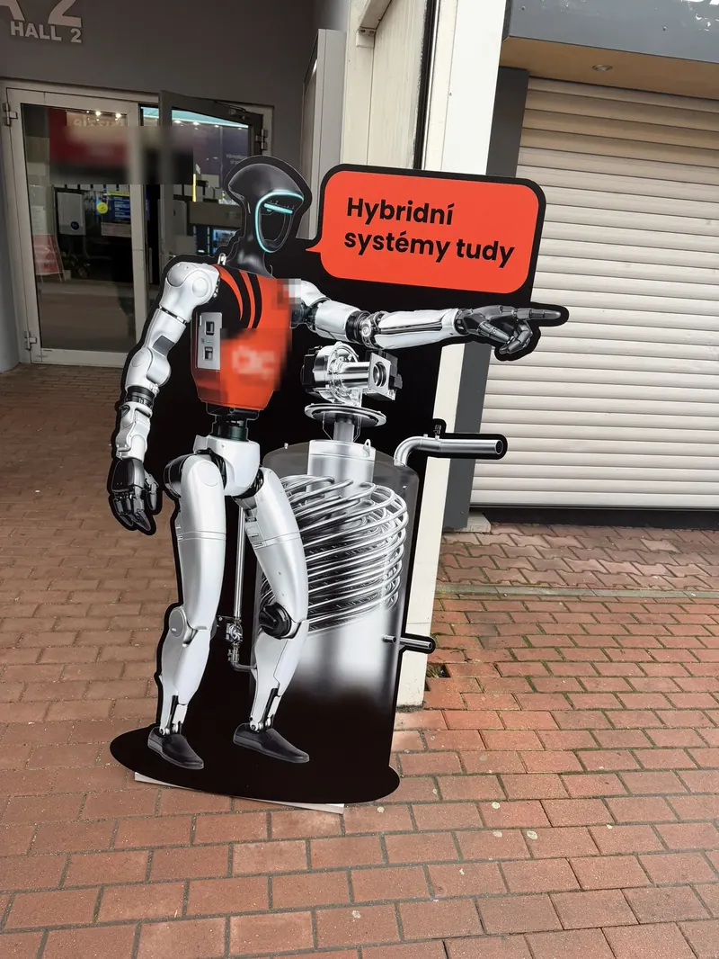 Humanoid s navigační cedulí u vstupu do expozice